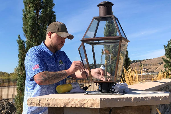 Plumbing technician inspecting a gas lantern.