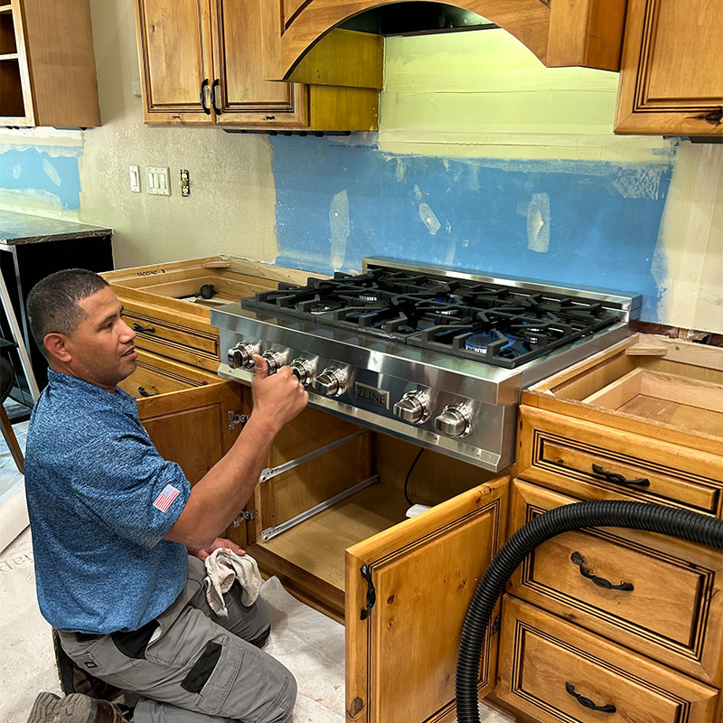 Plumber giving a thumbs up seeing the gas come on, on a gas stove.