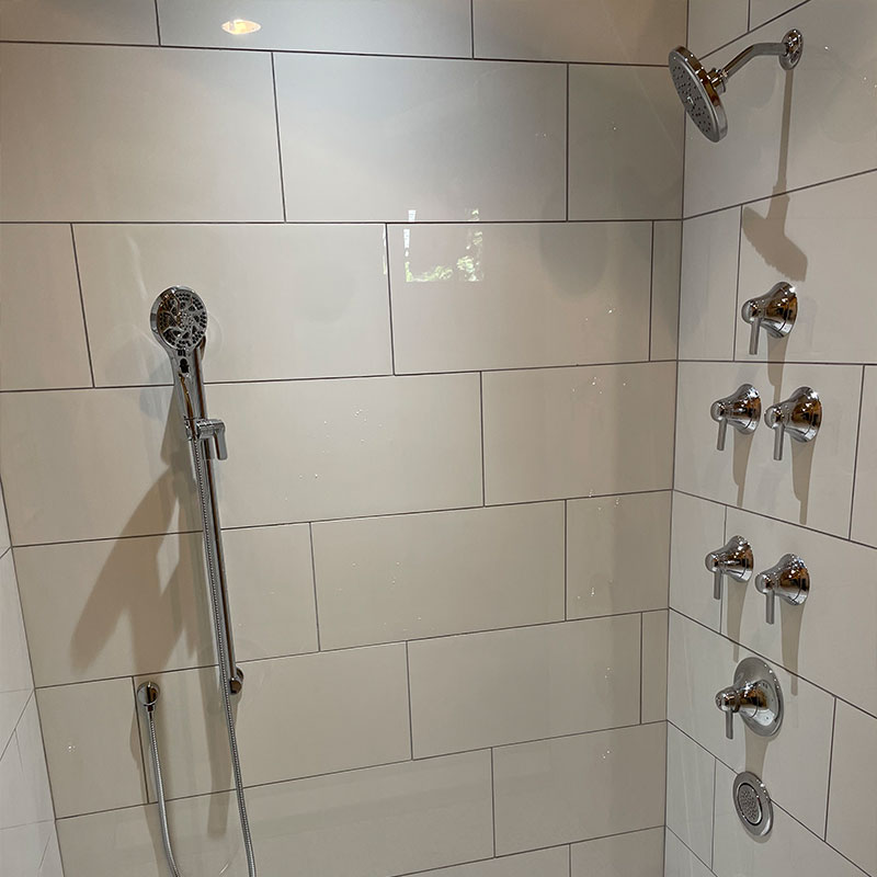 ADA shower with multiple control valves and shower heads.