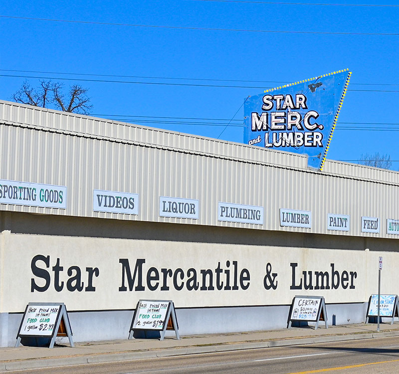 Picture of a the Star Mercantile & Lumber building with the Star Mer & Lumber sign on top of the building and a bright blue sky.