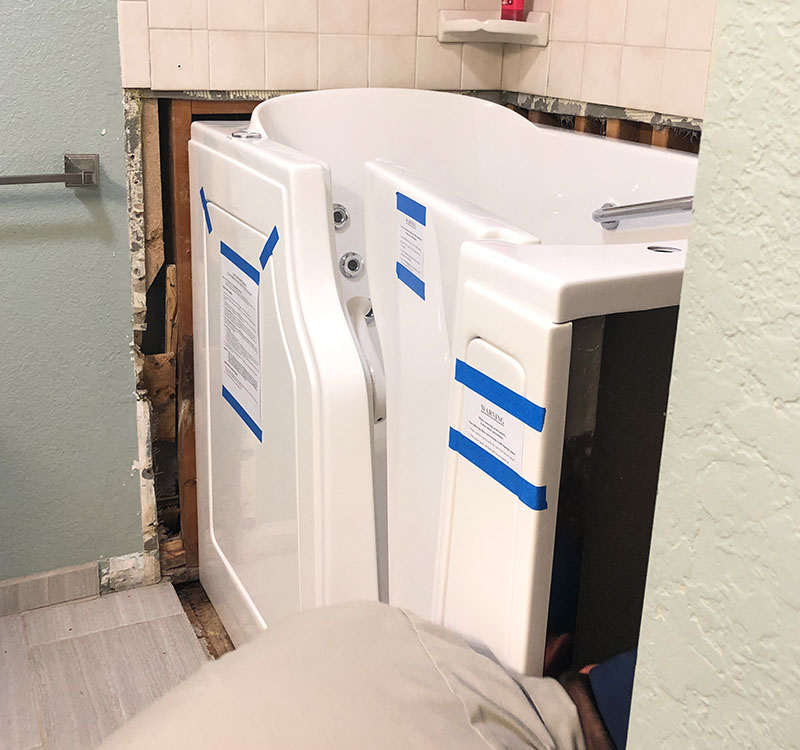 A walk-in bathtub being installed in place of a shower.
