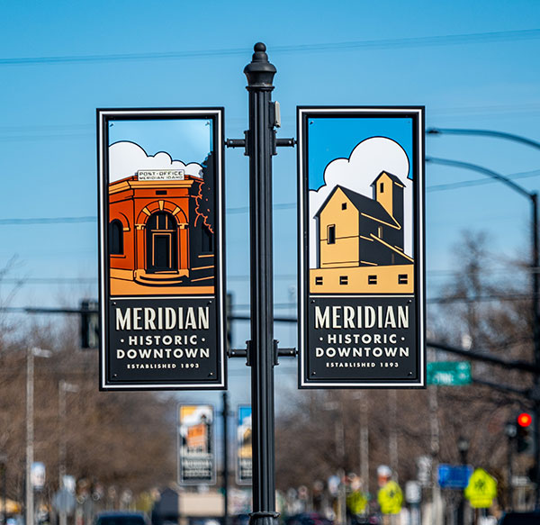 Flags on a pole with an image of old Meridian on the left and right side.