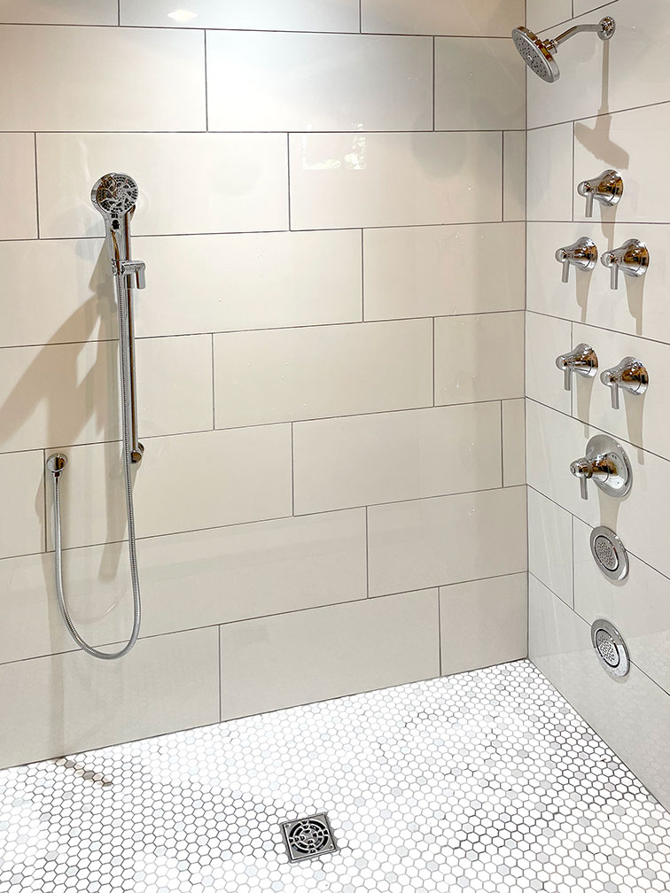 Accessible shower with multiple shower heads and and knobs.