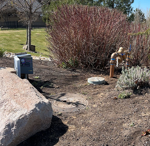 A yard showing sewer and water lines, with backflow pipes.